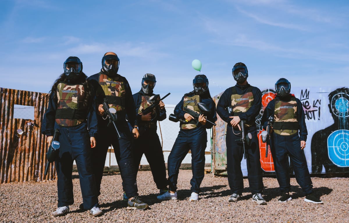 "Group of players in black paintball gear posing at Volcano Experience paintball field in Marrakech"