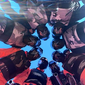 Group of players in black paintball gear posing at Volcano Experience paintball field in Marrakech"